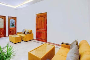 A living room with a sofa, a coffee table, and a door with a decorative panel.