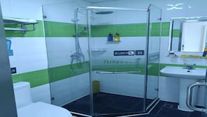 Ein Badezimmer mit einer Duschkabine, einem Waschbecken und einer Toilette.