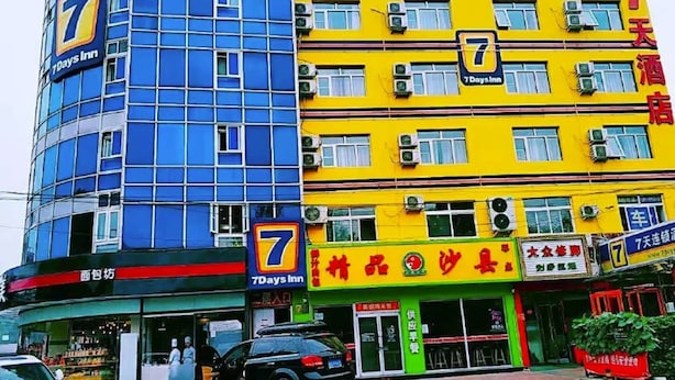 Ein 7 Days Inn Gebäude mit mehreren Etagen, Klimaanlagen und einer Schilder mit dem Hotelnamen.