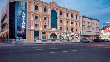 A hotel with a prominent 'AZAR' sign, multiple stories, and a modern glass facade.