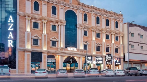 Un hotel con una amplia entrada en arco, numerosas ventanas y un letrero que indica que es un hotel.