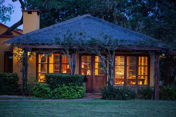 A house with a thatched roof, wooden windows, and a well-maintained garden. - El Transito Hotel Boutique (Concepción)
