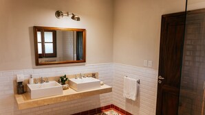 A bathroom with two sinks, a mirror, and a door. - El Transito Hotel Boutique (Concepción)
