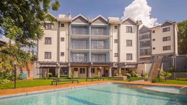 A multi-story hotel with a swimming pool in front. - Sports Road Apartments (Nairobi)
