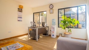 A modern office space with a desk, computer, and a water dispenser. - Sports Road Apartments (Nairobi)