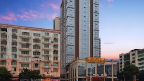 Un edificio de hotel alto con varios pisos y una fachada moderna de vidrio.