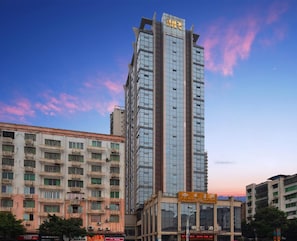 Een hoog hotelgebouw met meerdere verdiepingen en een moderne glazen gevel.