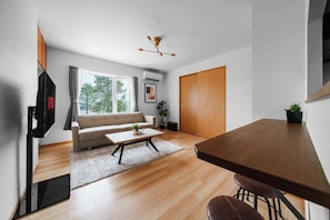Uma sala de estar moderna com sofá, mesa de centro e área de jantar com mesa e cadeiras.