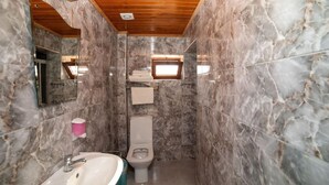 A bathroom with marble walls, a wooden ceiling, a sink, a toilet, and a window. - Gokceada Yakamoz Motel (Gökçeada)