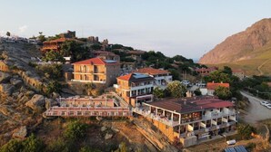 A coastal town with buildings on a hillside, including a hotel with balconies and a view of the sea. - Gokceada Yakamoz Motel (Gökçeada)