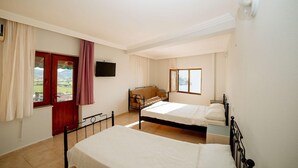 A bedroom with two beds, a window, a television, and a view of the outdoors. - Gokceada Yakamoz Motel (Gökçeada)
