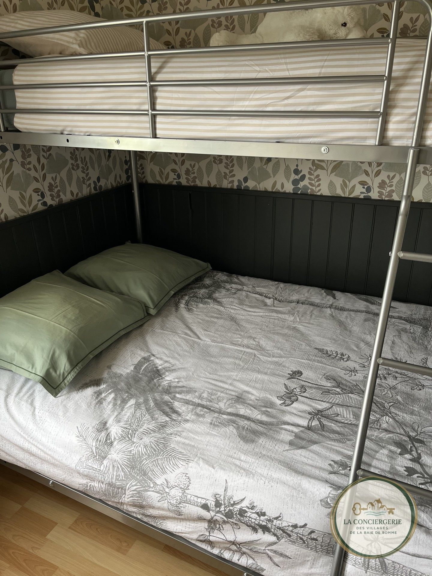 A bunk bed with a floral-patterned mattress and a headboard with a leaf design.