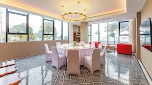 A modern dining area with a round table, white chairs, and a chandelier. - Holiday Inn Express Zhuhai Guishan Island (Zhuhai)