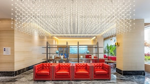 A lobby with a modern chandelier, red leather seating, and a reception desk. - Holiday Inn Express Zhuhai Guishan Island (Zhuhai)