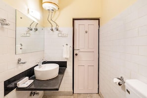 A bathroom with a white sink, mirror, and toilet, a door, and a towel rack. - Summit Tashi Ghang Heritage Resort Pelling (Gyalshing)