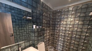 Een badkamer met een douche, toilet en wastafel.