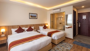 A hotel room with two beds, a large mirror, a shower area, and a door with a lock. - Hotel Crystal Pashupati (Kathmandu)