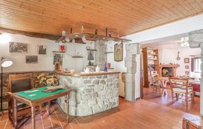Ein rustikaler Innenraum mit einer Steinbar, Holzmöbeln und einem gefliesten Boden.