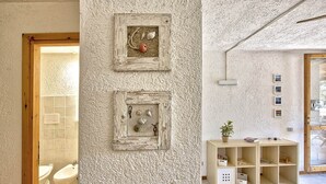 Een badkamer met een houten deur, een toilet en een douchetoilet.
