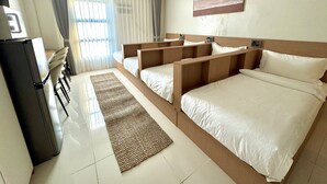 A hotel room with a bed, a desk, and a refrigerator. - Royal Oceancrest Panglao 1 (Dauis)