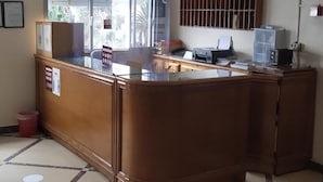 A reception desk with a clock, a window, and a wall-mounted security camera. - Hotel Tarik (Fnideq)
