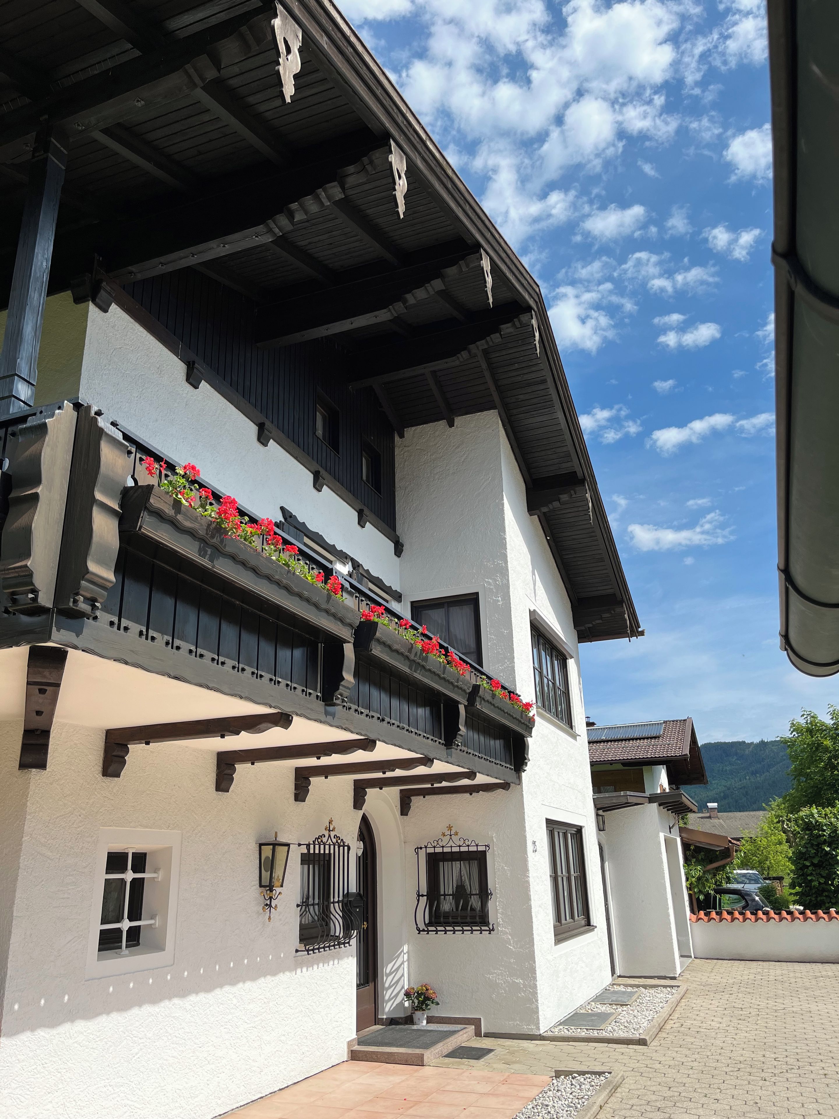 A two-story building with balconies, a tiled roof, and a clear sky.