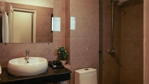 A bathroom with a white sink, a mirror, a toilet, and a shower area. - Faletti's Express - Islamabad (Islamabad)