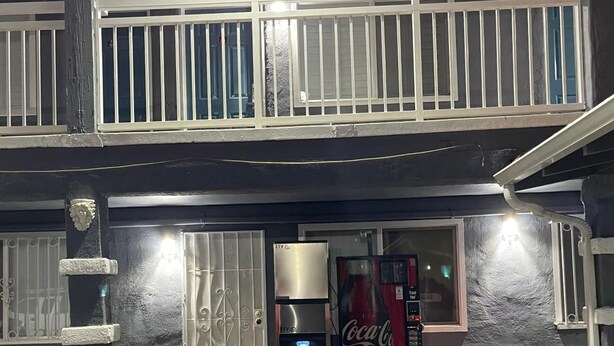A building with a gated entrance, a Coca-Cola vending machine, and a security camera. - Studio6 Oakland, CA - San Francisco Berkeley Area (Oakland)