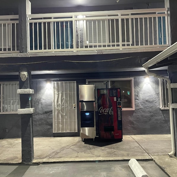 A building with a gated entrance, a Coca-Cola vending machine, and a security camera. - Studio6 Oakland, CA - San Francisco Berkeley Area (Oakland)