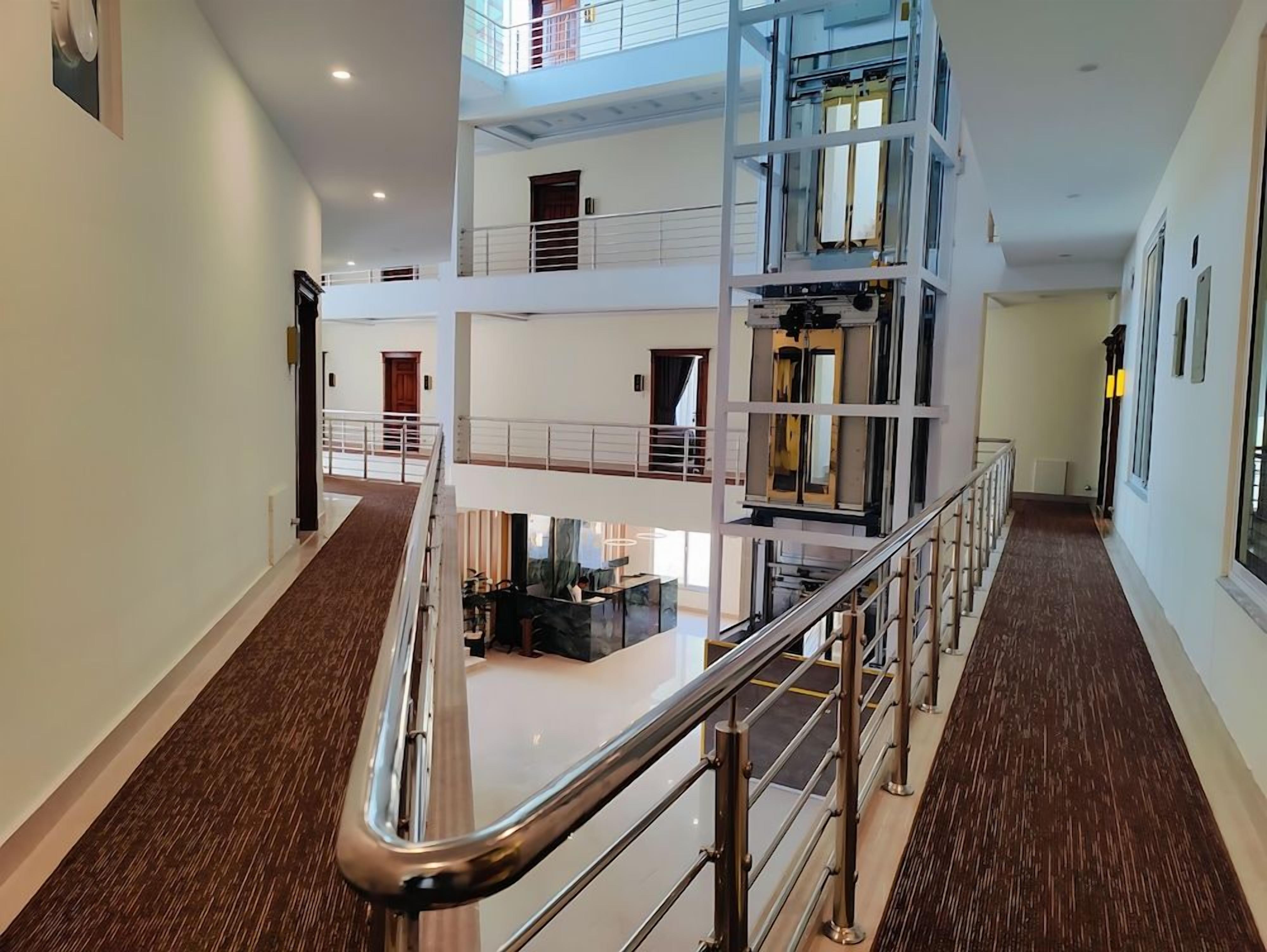 Un interior amb diversos nivells, una escala central, una zona de recepció i un entrepissos.