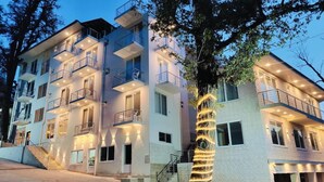 A multi-story hotel with balconies, a central staircase, and a paved courtyard. - Pinemont Hotel Murree (Murree)