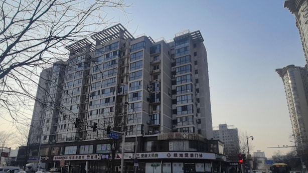 Un edificio de varios pisos con locales comerciales en la planta baja.