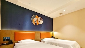 Una habitación de hotel con dos camas, un cabecero de madera, un reloj de pared y piso alfombrado.