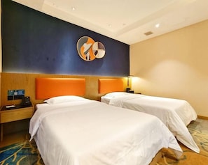 Una camera d'albergo con due letti, un poggiatesta in legno, una sveglia a parete e un pavimento rivestito di moquette.