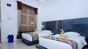 Habitación de hotel con dos camas, un ventanal con cortinas, un cesto de basura azul y un cartel en la pared.