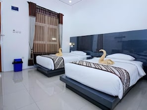 Habitación de hotel con dos camas, un ventanal con cortinas, un cesto de basura azul y un cartel en la pared.