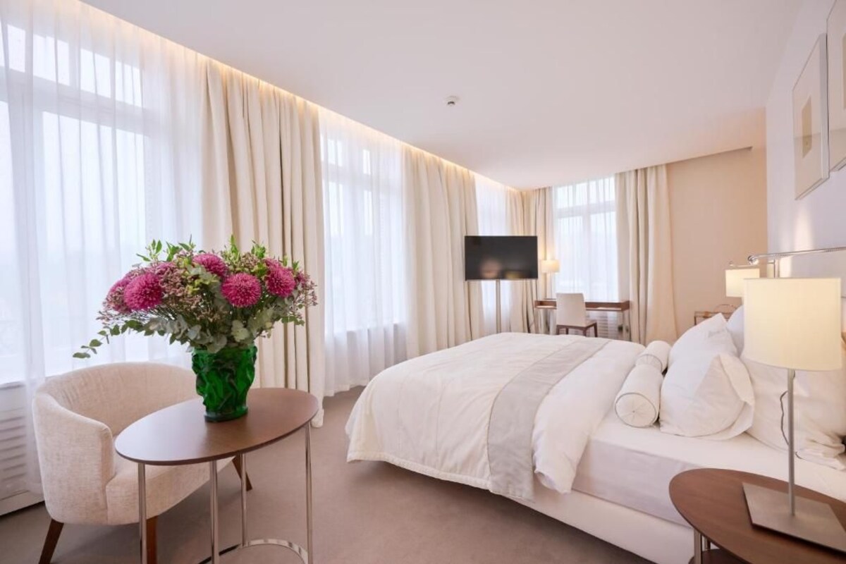 Een hotelkamer met een bed, een televisie, een bureau en een stoel.