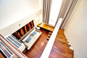 A modern interior with a sofa, a small table, and a staircase. - Ferra Premier Boracay by JG (Boracay Island)