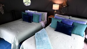 A room with two beds, each with a white textured bedspread and multiple pillows in various colors. There is a small table with a lamp and decorative items on the wall. - Unique Glamping Dome with Private Firepit Luxury Escape in Salt Lick, Kentucky (Salt Lick)