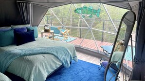 A tented room with a bed, a small table, and a chair. - Unique Glamping Dome with Private Firepit Luxury Escape in Salt Lick, Kentucky (Salt Lick)