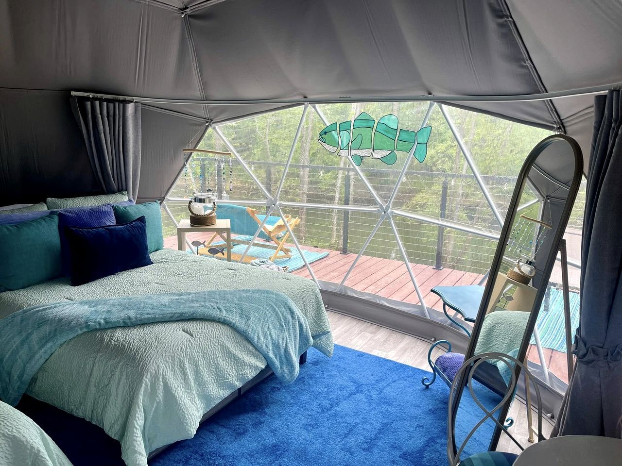 A tented room with a bed, a small table, and a chair.