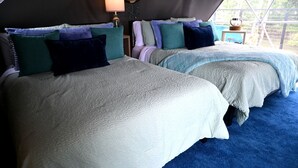 A tented accommodation with two beds, each with a textured blanket and pillows, a bedside lamp, and a view of the outdoors. - Unique Glamping Dome with Private Firepit Luxury Escape in Salt Lick, Kentucky (Salt Lick)