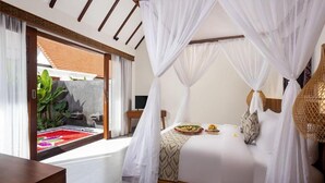 A bedroom with a canopy bed, a view of a garden, and a wooden bench. - Jenna Villa by Genuinehost (Ubud)