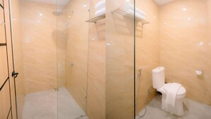 Une salle de bain avec une douche à parois de verre, des toilettes et un porte-serviettes.