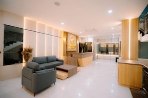 Un interior moderno con un sofá gris, detalles de madera y un mostrador de recepción.