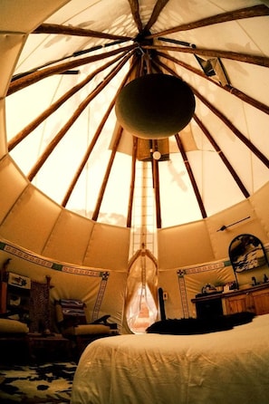 Una habitación con una estructura grande y circular, similar a una tienda de campaña, que tiene un objeto colgando en el centro.
