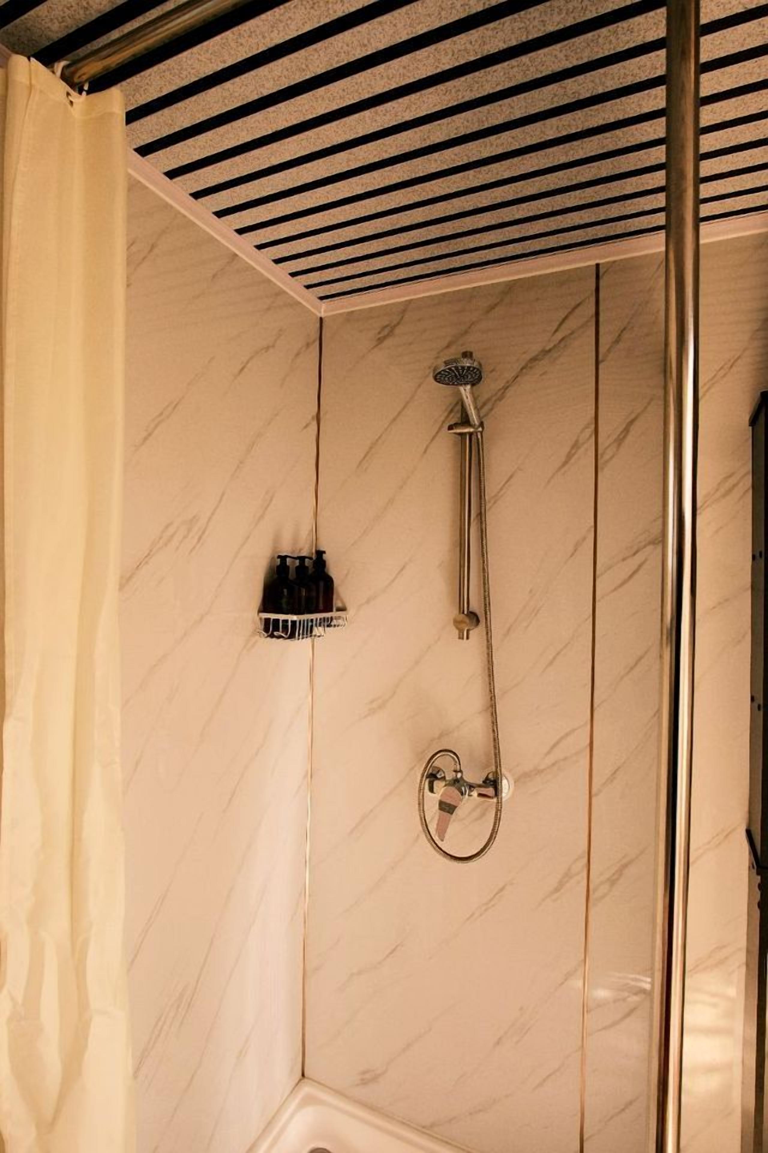 A bathroom with a shower, a towel rack, and a curtain.