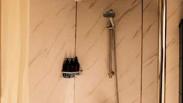 A bathroom with a shower, a towel rack, and a curtain.