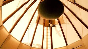 A room with a large, circular, tent-like structure with a hanging object in the center.