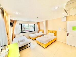 A hotel room with two beds, a window with a city view, a desk with a chair, and a door with a lock. - Abcyq Hotel Bangkok (Bangkok)